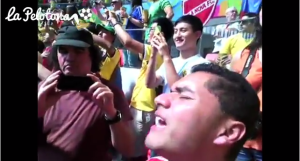hincha colombiano cantando el himno de su pais con emocion