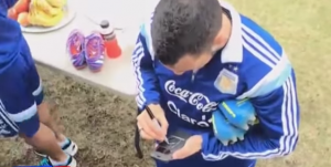 Tevez firma los celulares de los aficionados argentinos