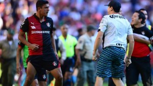 Venegas del Atlas empuja a uno de los aficionados que se metieron a la cancha