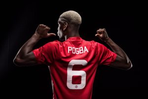 Paul Pogba mostrando el dorsal que llevará en el Manchester United
