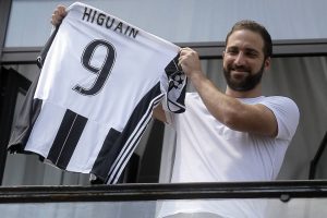Gonzalo Higuaín sosteniendo la camiseta de la Juventus