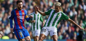 dani ceballos disputa un balon con messi en el barcelona betis por la liga