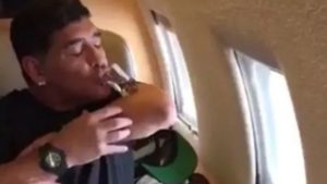 maradona tomando trago en un avion